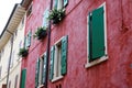 Red house facade with green colored window shutters