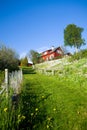 A red house on the grass hill