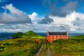 A red house in the Ireland countryside contrasting with the cloudy sky and the grren fiends Royalty Free Stock Photo