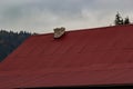 Red house roof with red brick chimney. Ceramic chimney, metal roof tiles, gutters