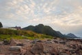 Red house on the shore with view to mountain and sunset on the sea in the Norway at summer Royalty Free Stock Photo