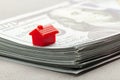 Red house on a stack of money. The concept of taxes or real estate loans