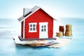 Red house on wooden background with banknotes Royalty Free Stock Photo