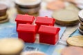 Red houses by stacks of coins representing house financing.. Royalty Free Stock Photo