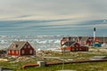 Red houses in the town Ilulissat, view over iceberg in the Disko bay to Qeqertarsuaq island and the glacier in the background,