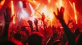 Red-hued lighting at a concert with an enthusiastic crowd, hands in the air. Dynamic music festival vibe Royalty Free Stock Photo