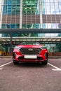 Red Hyundai Tucson N-Line front view. Korean compact crossover SUV parked in front of modern building with glass facade Royalty Free Stock Photo