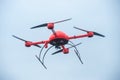 Red industrial drone flies over metal structures industrial faci