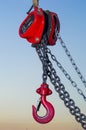 Red Industrial hook hanging on reel chain and blue sky sunset ba Royalty Free Stock Photo