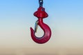 Red Industrial hook hanging on reel chain and blue sky sunset ba Royalty Free Stock Photo