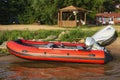 Red inflatable rubber boat with a motor near the lake shore, fishing, tourism Royalty Free Stock Photo