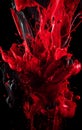 Red ink and black color creating abstract explosion. Smooth texture, fast motion and splash. Creative & colourful studio isolation Royalty Free Stock Photo