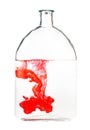 Red ink dissolves in water in bottle isolated Royalty Free Stock Photo