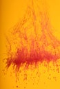 Red ink dissolving over orange