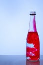 Red ink mixed with water in a glass bottle on a light background Royalty Free Stock Photo