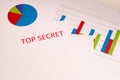 Red inscription TOP SECRET on a white sheet. Charts and graphs on white paper. Secrets and conspiracies. Secret archives. Royalty Free Stock Photo