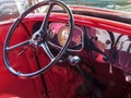 Red interior with classic car dashboard and steering wheel. Royalty Free Stock Photo