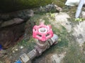 A red iron water valve, showing signs of rust, is connected to an iron pipe. Royalty Free Stock Photo
