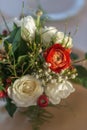 Red and ivory floral arrangement prepared for reception, wedding table with candle and setting, winter concept