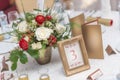 Red and ivory floral arrangement prepared for reception, wedding table with candle and setting, winter concept