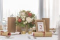 Red and ivory floral arrangement prepared for reception, wedding table with candle and setting, winter concept