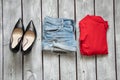 red jacket denim shorts and black leather shoes on a white wooden table, women's clothing Royalty Free Stock Photo