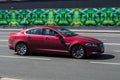 Red Jaguar XF riding on the highway. Side view of shiny compact executive car driving in the street Royalty Free Stock Photo