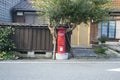 Red Japanese mailbox on a street in the city of Oji on the island of Sado.