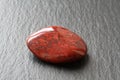 Red jasper stone on a black stone board. Closeup. Royalty Free Stock Photo