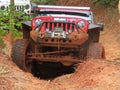 Red jeep attempts to climb a big hill off road