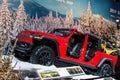 Red jeep with the doors off being displayed at a auto show