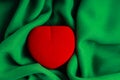 Red jewel box heart shaped gift present on green fabric wavy cloth Royalty Free Stock Photo