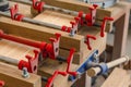 Red joiner clamps are fixed on product, gluing of boards