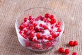 Red juicy berries of a viburnum with sugar in a glass jar on a wooden background. For making jam, tea. Medicinal plant. Royalty Free Stock Photo