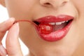 Red and juicy. Cropped closeup shot of a beautiful young woman with a cherry in her mouth. Royalty Free Stock Photo