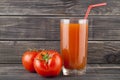 Red, juicy, fresh tomatoes and juice on a wooden background Royalty Free Stock Photo