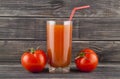 Red, juicy, fresh tomatoes and juice on a wooden background Royalty Free Stock Photo