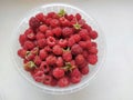 Red juicy raspberries in plastic box container on white background, top view. Raspberries in a plastic bucket. Ripe razz Royalty Free Stock Photo