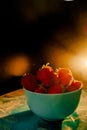 red juicy ripe strawberries in a blue vase on a black background. Drops of water, warm sunshine, back light, vertical Royalty Free Stock Photo