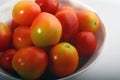 Red, juicy tomatoes isolated in a white round bowl Royalty Free Stock Photo