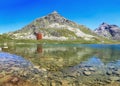 The red Julier Theater Tower on the Julier Pass (2284 m above sea level) with reflection