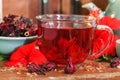 Red karkade hibiscus red sorrel tea in glass mug with dry tea cu