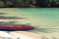 Red Kayak on the tropical white sand beach with sea waves. Scenic relaxing scenery
