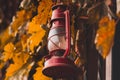 Red kerosene lamp on the fence with leaves Royalty Free Stock Photo