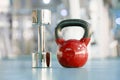 Red kettlebells and chrome dumbbell in gym