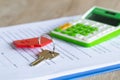 Red key ring Placed on the sales contract And a blurred calculator The concept of a sales representative. The customer is giving Royalty Free Stock Photo