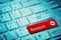 Red key with text Restore on blue digital laptop keyboard Royalty Free Stock Photo