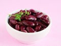 Red kidney beans in white bowl over pink background Royalty Free Stock Photo