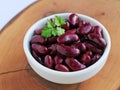 Red kidney beans in white bowl over wooden board Royalty Free Stock Photo