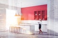 Red kitchen corner with bar and shelves, woman
